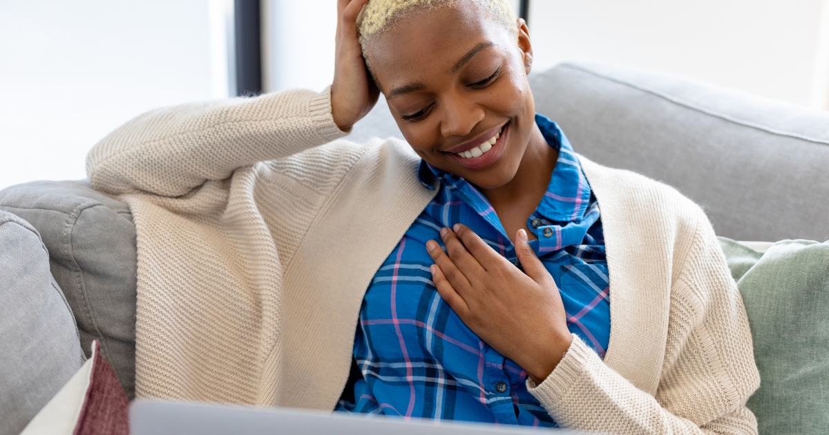 Featured image: Diverse woman sitting alone with her laptop, happily reflecting on a balanced digital life and managing digital anxiety - Read full post: Coping with Digital Anxiety and Online Overwhelm | Plumm
