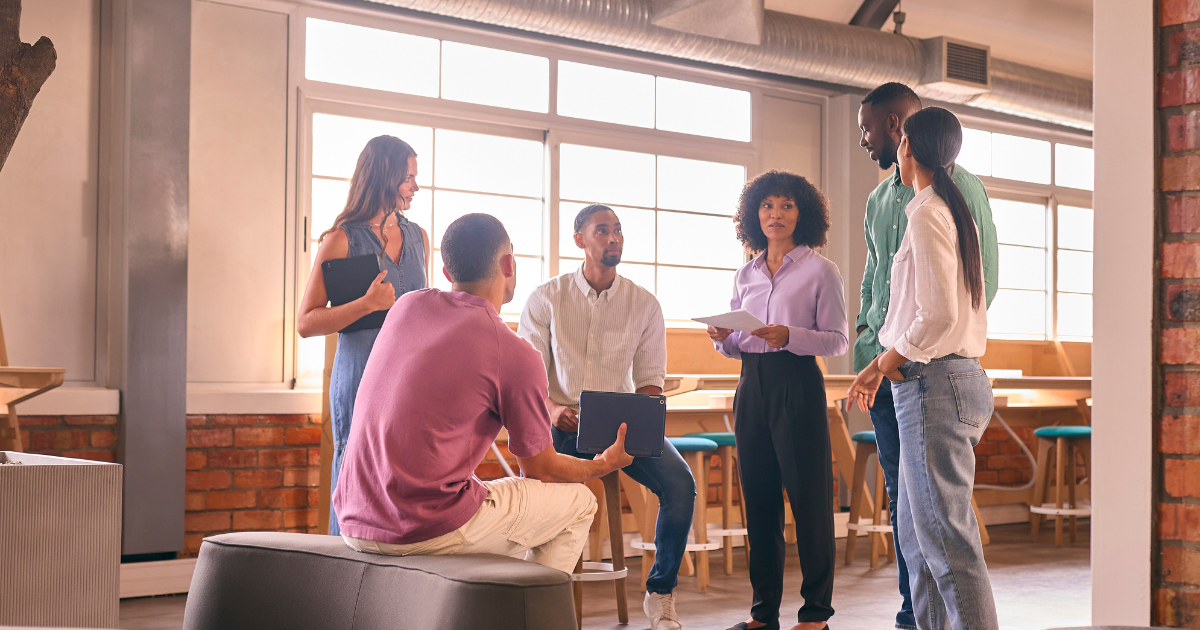 Featured image: Group of diverse team members discussing inclusivity and supporting each other in a positive, respectful work environment. - Read full post: A Guide to Communicating Feelings of Discrimination and Marginalisation