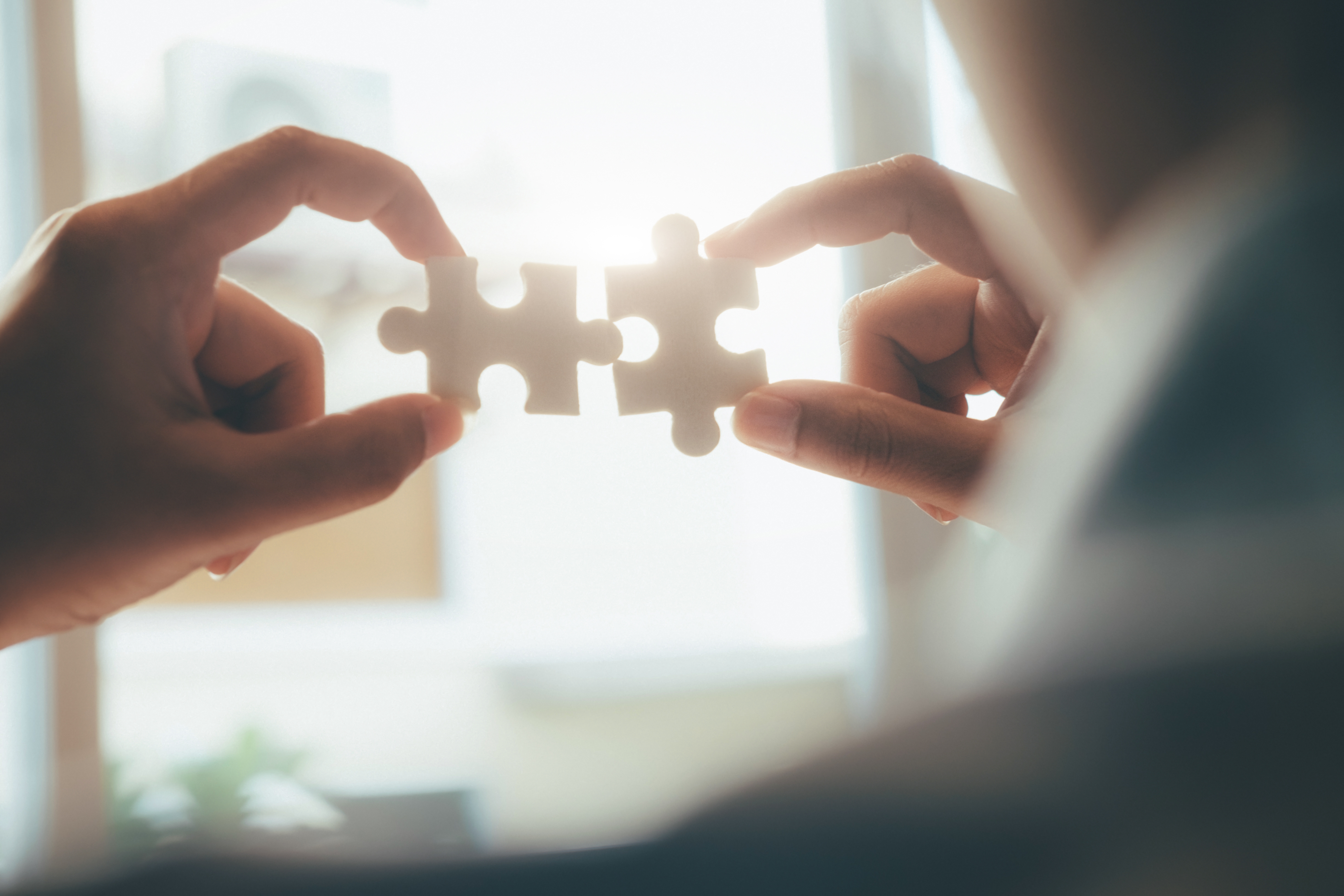 Featured image: Two people holding puzzle pieces that fit together, symbolising connection at work - Read full post: Rebuilding Connection at Work